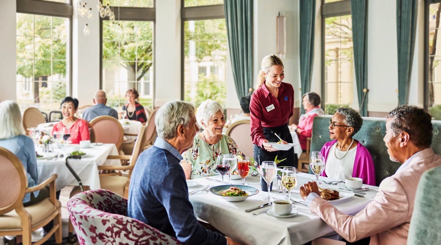 Two couples enjoy a meal in a Vi dining room.