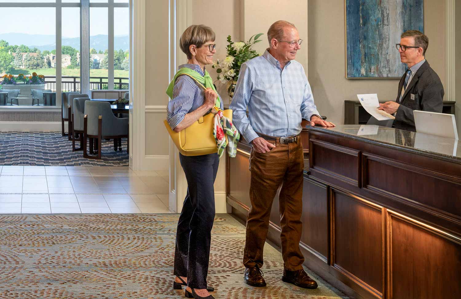 A couple talking to the front desk at Vi at Highlands Ranch. 