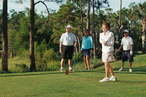 Two couples golf at Vi at Bentley Village.