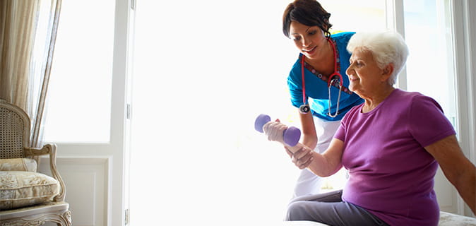 A nurse helping a resident exercise.