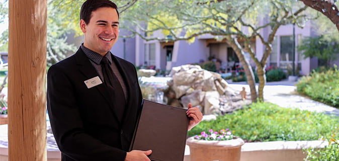 Host smiling with a menu.