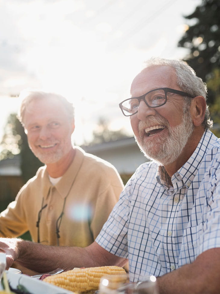 Men eating outside and laughing. 