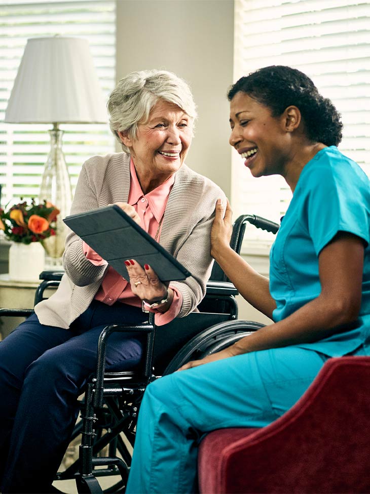 Woman and nurse looking at an iPad. 