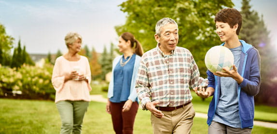 A multigenerational family walks outside.