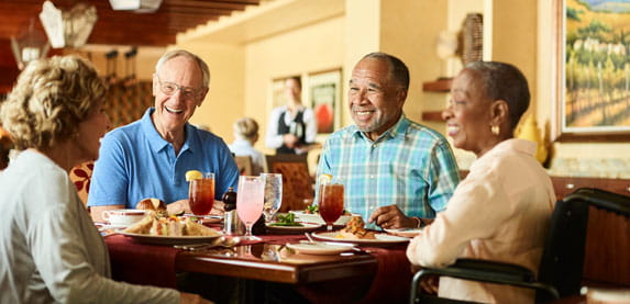 Four people sit around a dining table.
