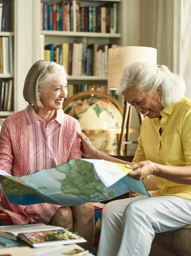 Two women sit and look at a map together.