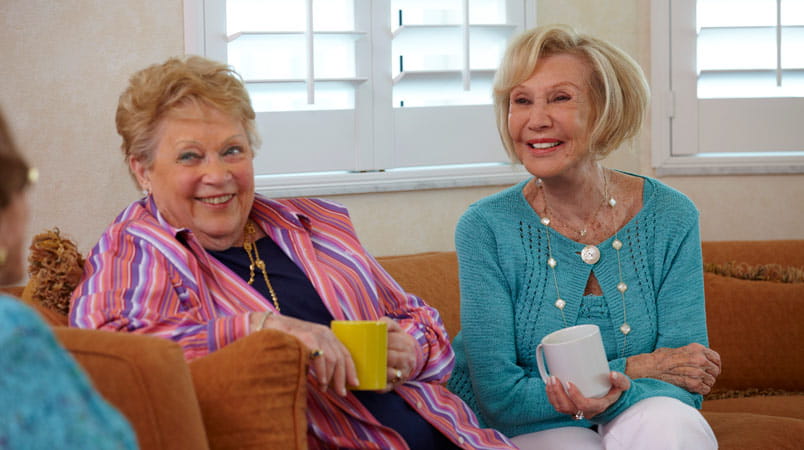 Women visit while drinking coffee.