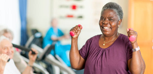 A woman lifts free weights.