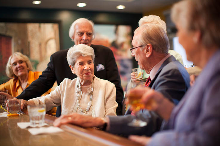 A group of residents sit and chat at the bar.