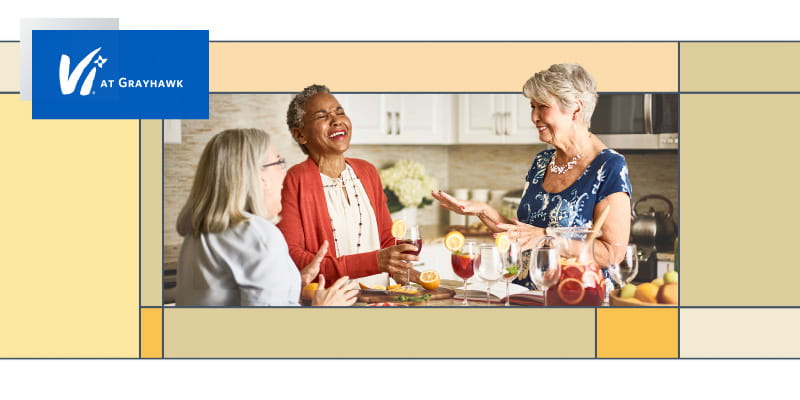Three women drinking sangria and laughing.