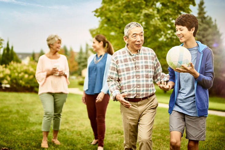 A multigenerational family walks outside.