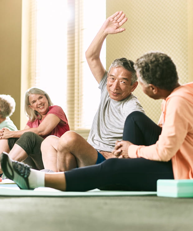 Several residents stretch together in the gym.