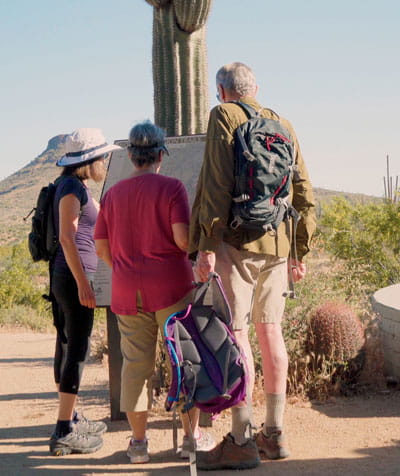 Residents stand at a trailhead. 