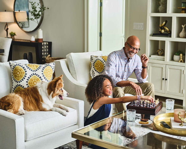 A man and his granddaughter play chess.