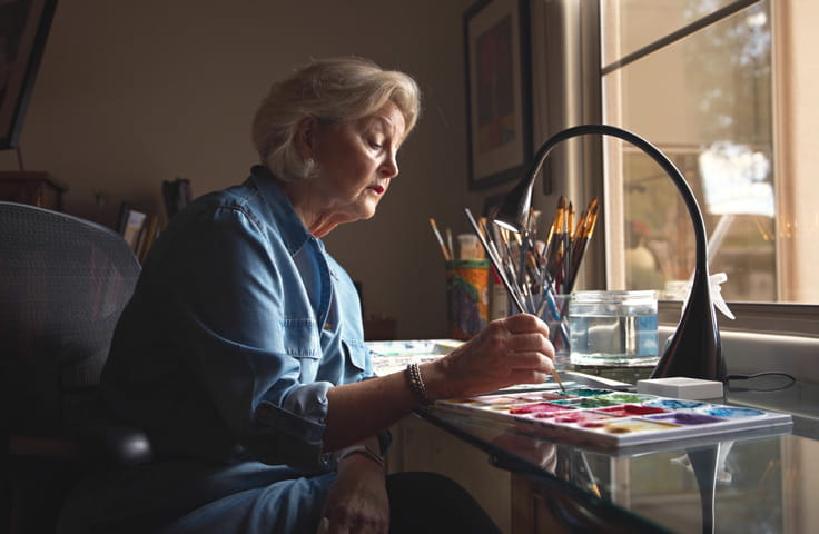 Resident Robin Woodworth paints in her apartment studio.