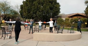 Vi at Grayhawk resident Laura Ensign leads a fitness class outdoors.