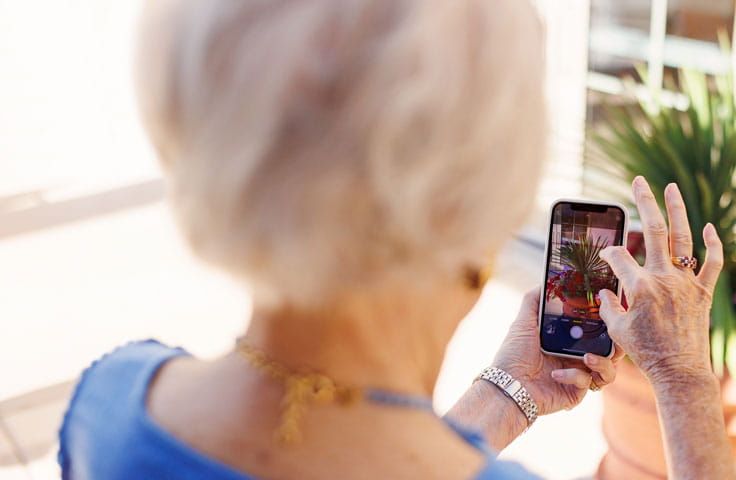 A woman takes a photo on her phone.