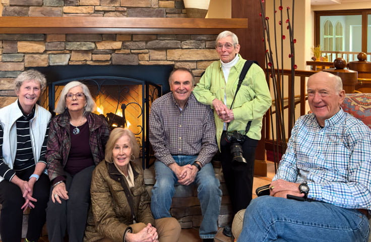 Members of Vi at Grayhawk's photography group pose in front of the community fireplace.