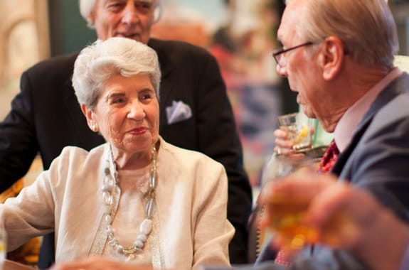 Residents sit and chat at a bar.