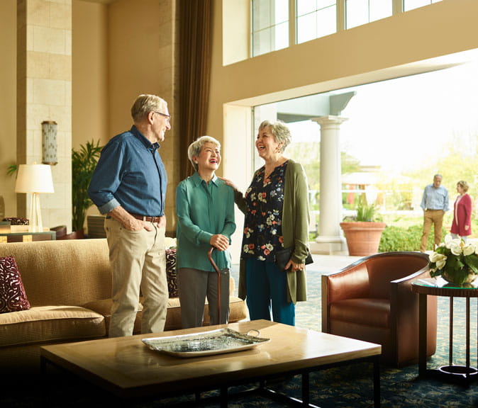 Friends laugh together in the Vi at Silverstone lobby.