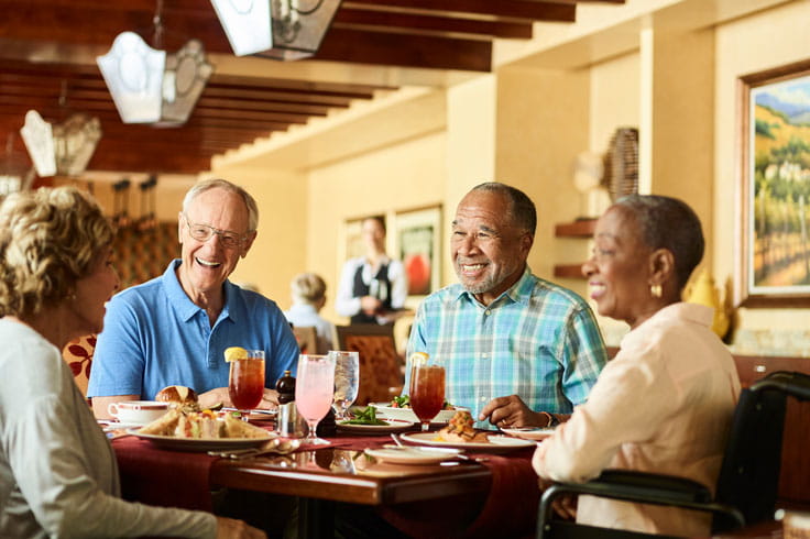 Two couples sit together at dinner.