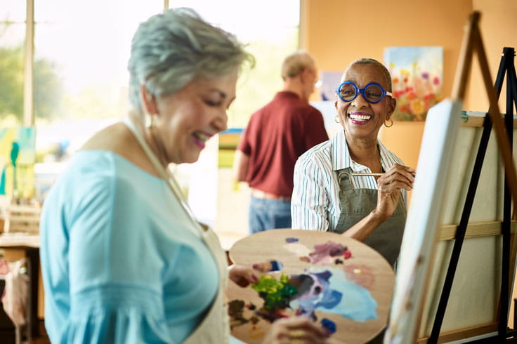 Two women paint in art class.