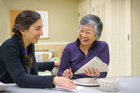 Employee talking to woman and smiling.