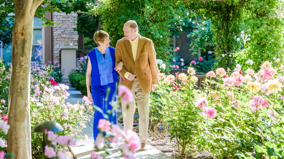 Man and woman walking outside and smiling. 