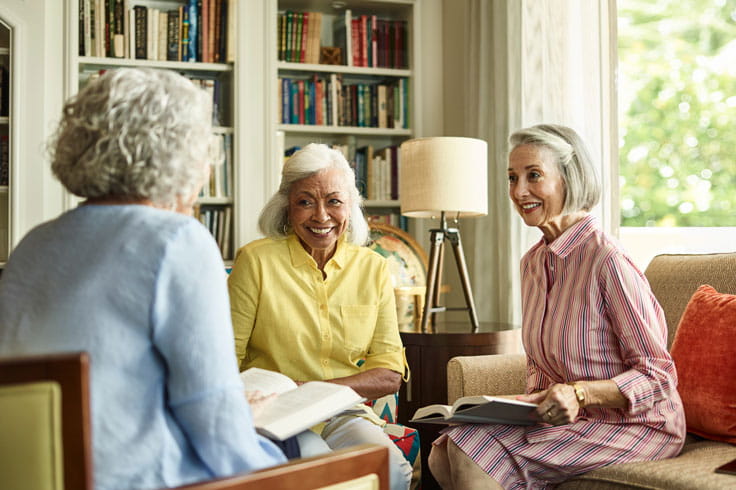 A group of women discuss a book.