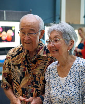 Two residents admire pieces at the annual art show.
