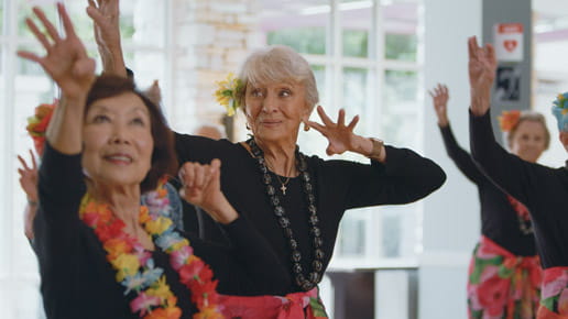 Hula class participants dance.