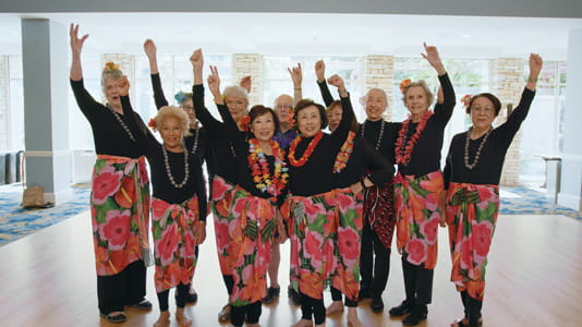Eva's hula class participants smile together.