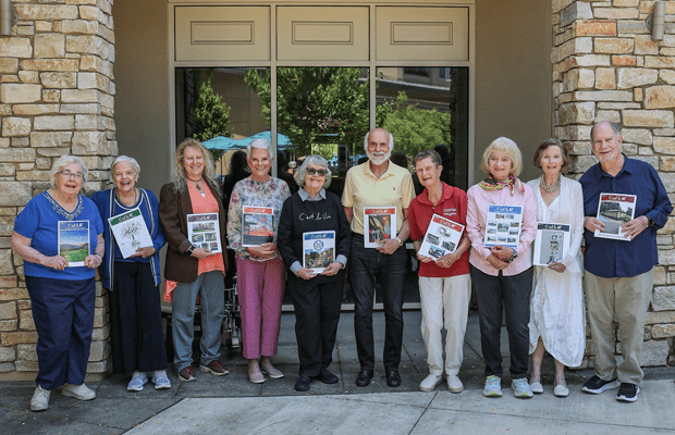 The board for Vi at Palo Alto's resident-led magazine pose outside with an issue of the publication.