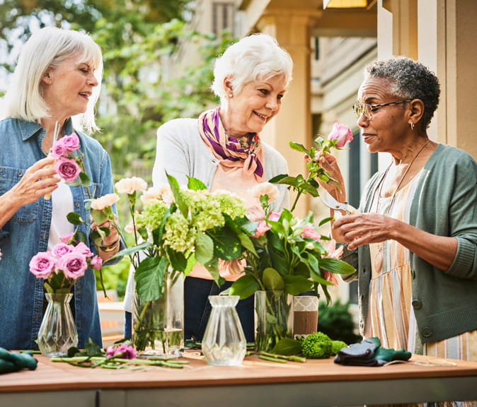 Several women arrange flowers.