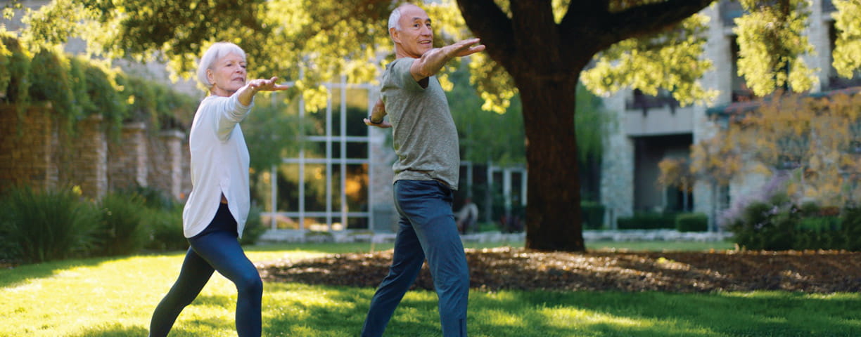 A man and woman practice yoga on the lawn at Vi at Palo Alto.