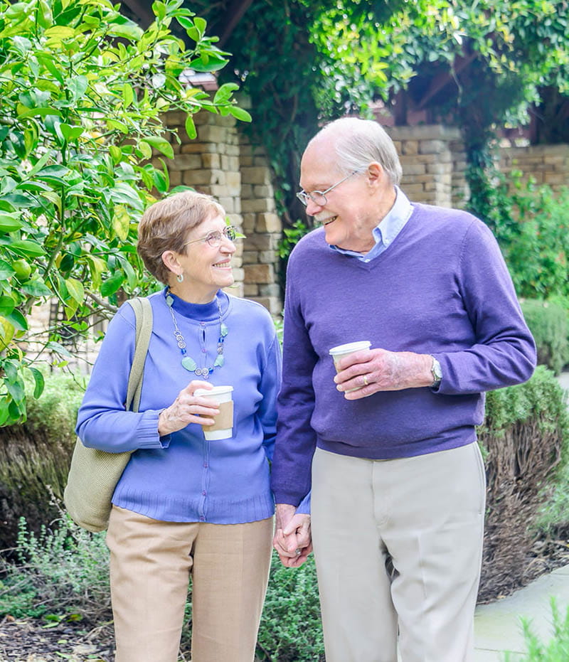 Man and woman walking outside smiling. 