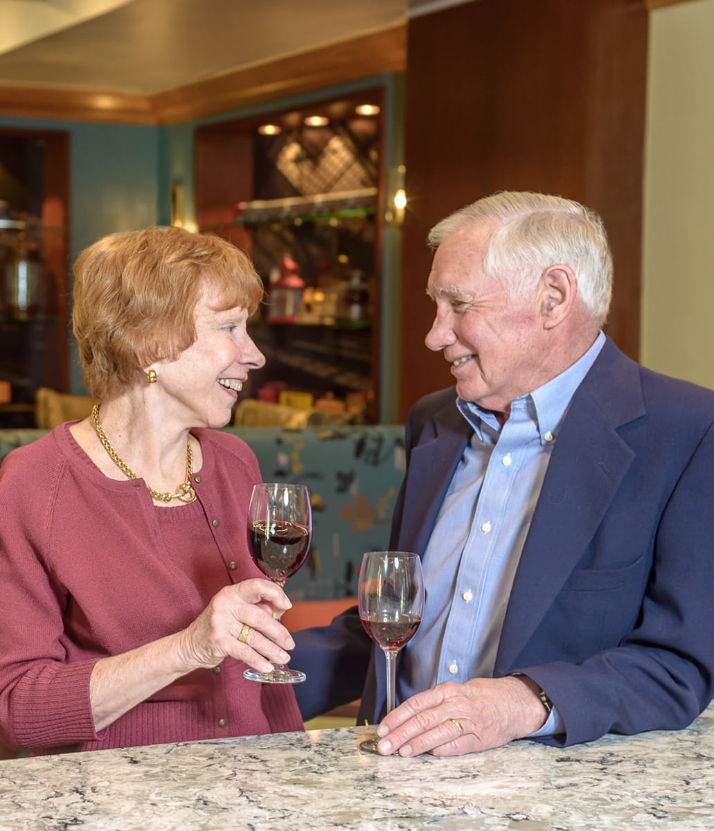 Man and woman sitting at bar and smiling. 