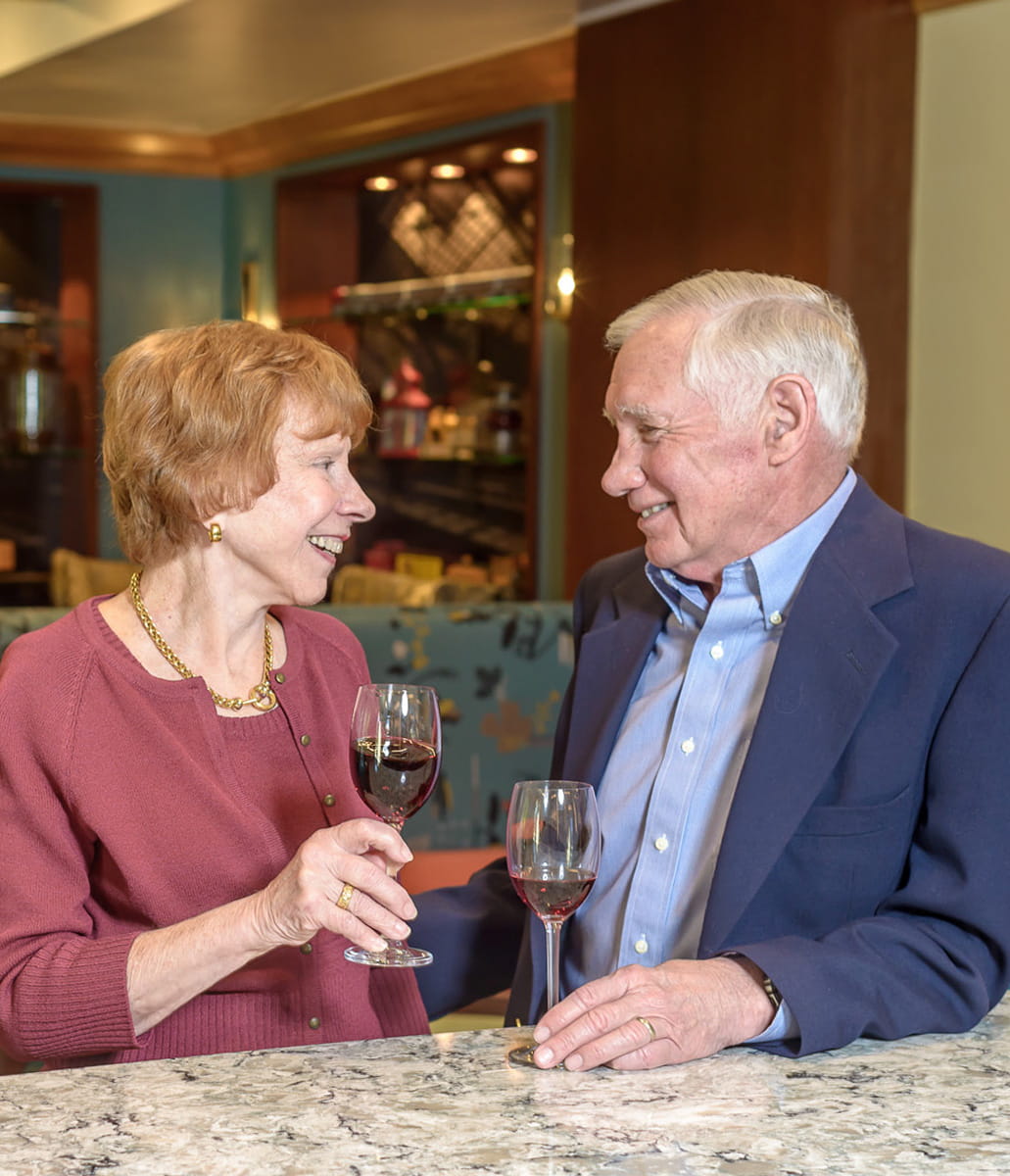Man and woman sitting at bar and smiling.