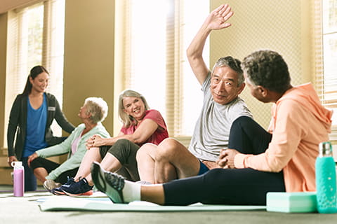 People talking and stretching in a group exercise class