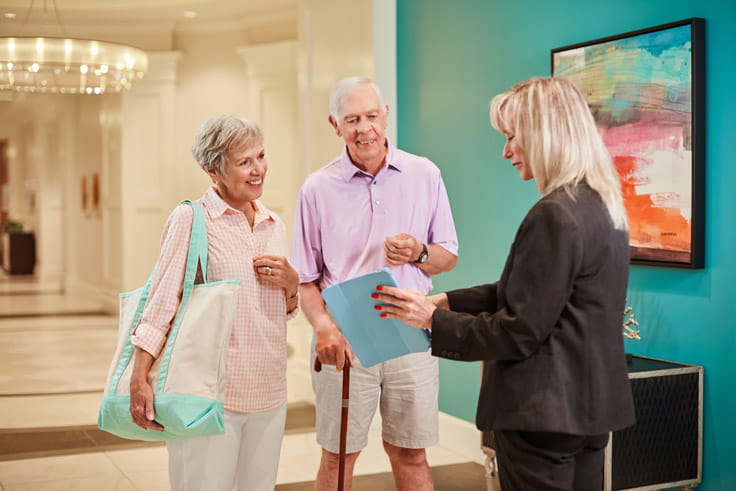 A couple reviewing paperwork with an employee.