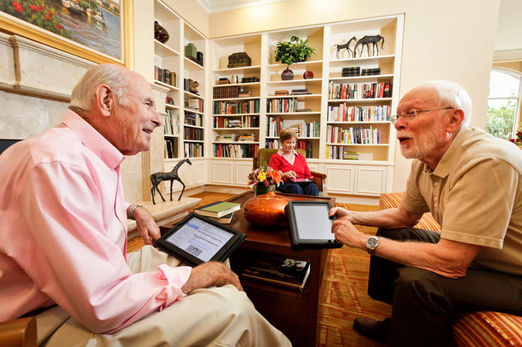 Two men chat in the library.