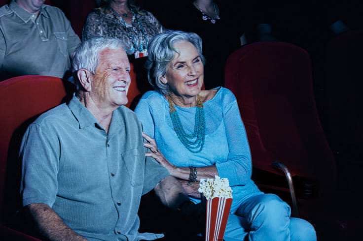 A couple watches a movie in a theater