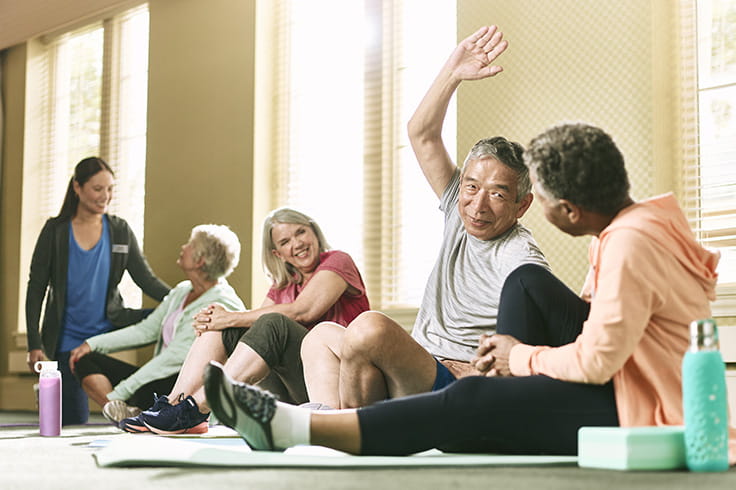 People talking and stretching at a group exercise class