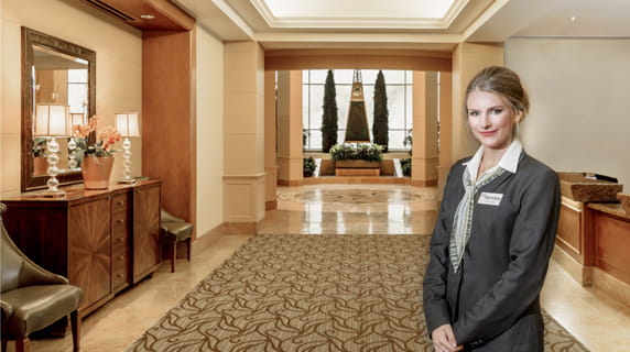 A Vi at La Jolla Village employee standing in front of the concierge desk