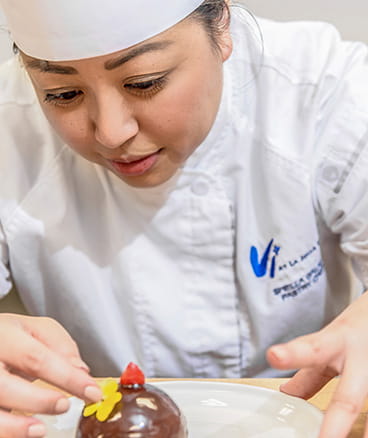 A pastry chef makes a dessert.