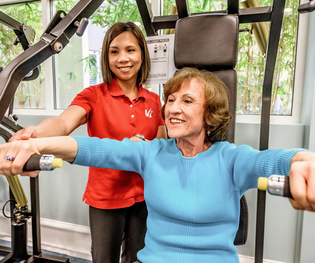A personal trainer works out with a resident.