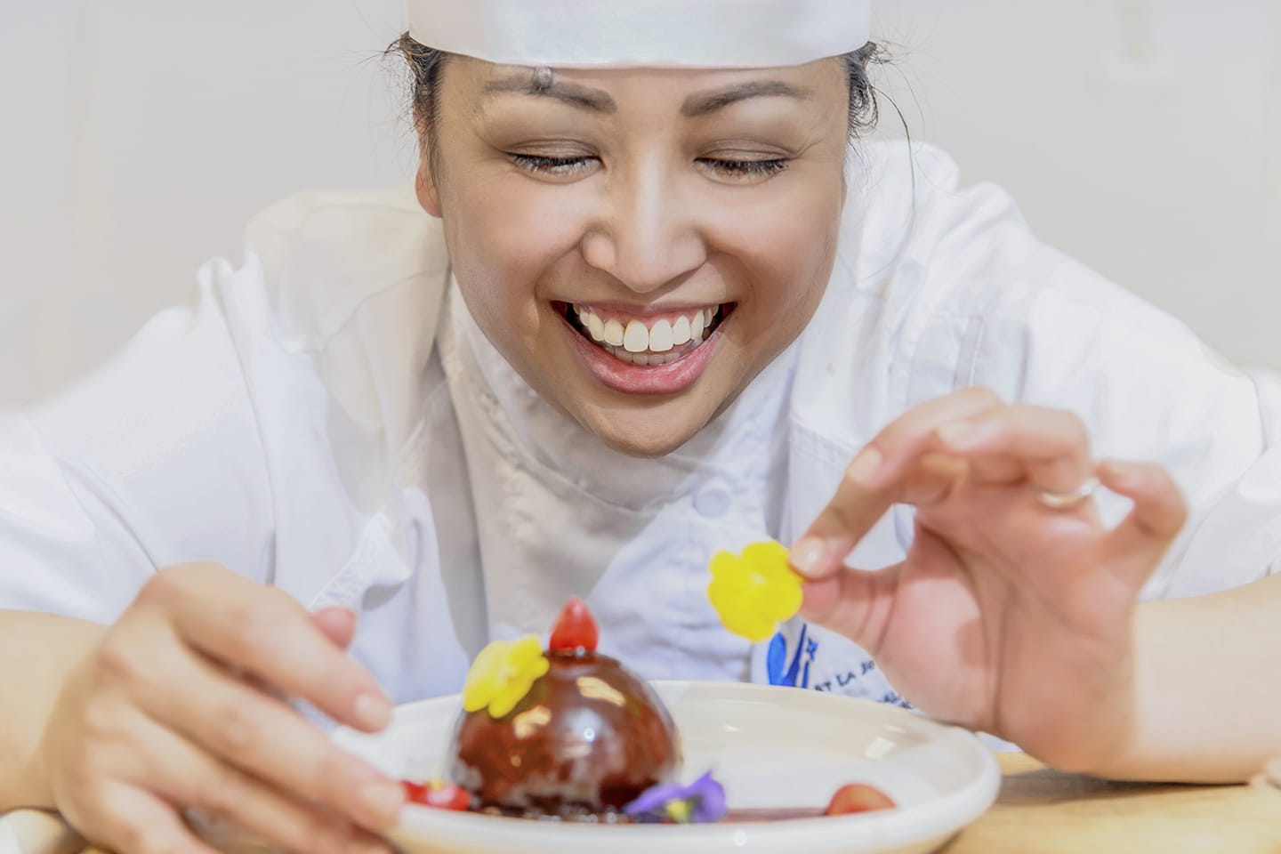 A pastry chef decorates a dessert.