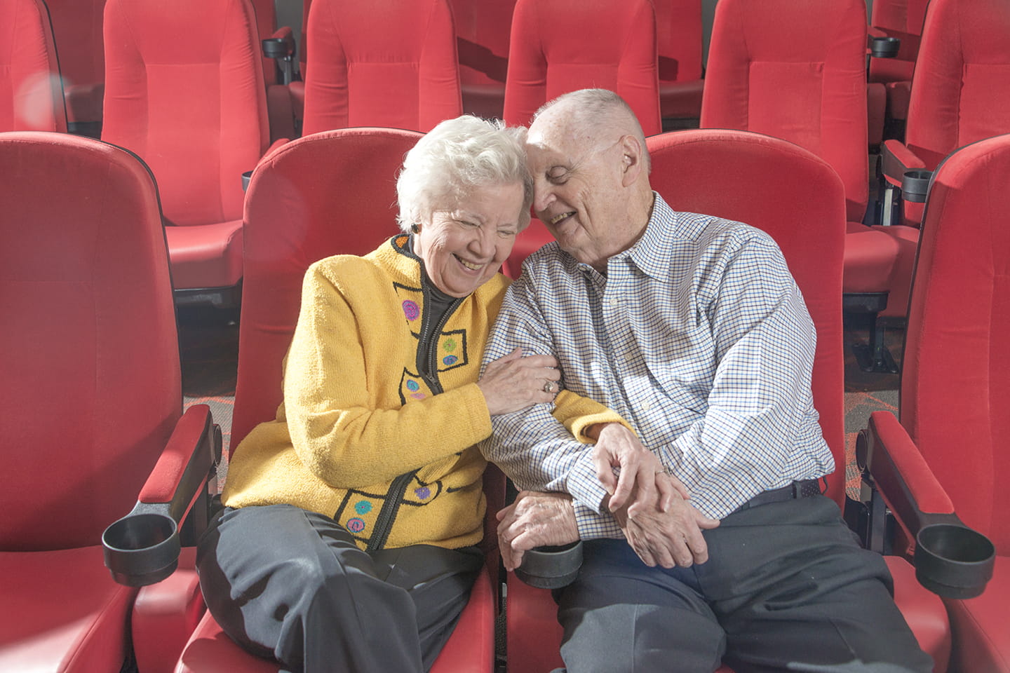 A couple sits in the movie theater.