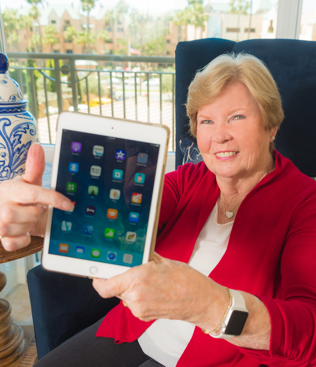 A resident holds up her tablet to the camera.