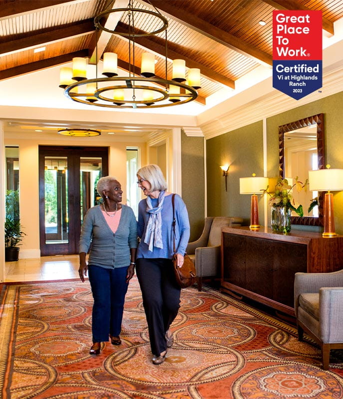 Two women walk in the lobby. 